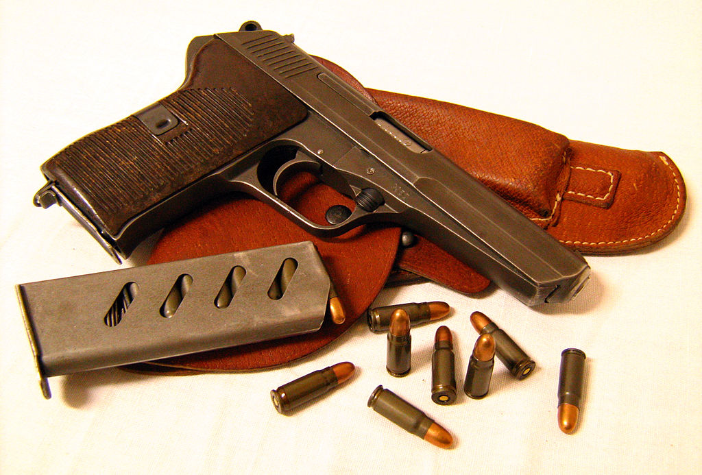 A picture of a Tokarev pistol with magazine, bullets and leather holster